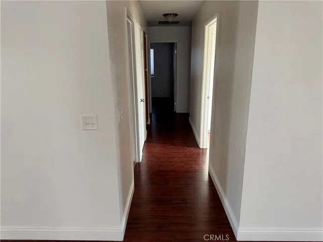a view of a hallway with wooden floor
