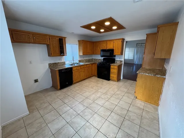 a kitchen with stainless steel appliances granite countertop a refrigerator a stove top oven and a sink with granite countertops