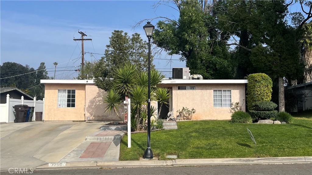 a view of a white house with a yard and plants