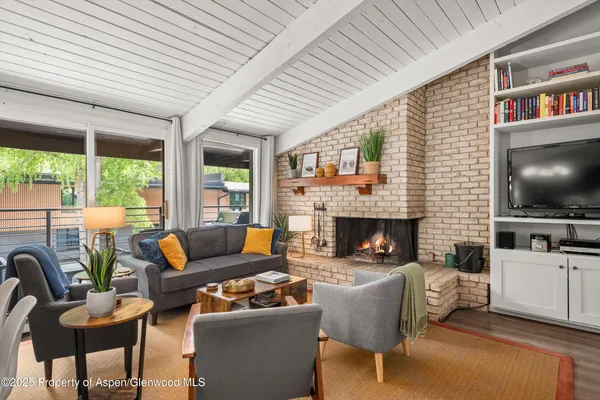 a living room with furniture a flat screen tv and a fireplace