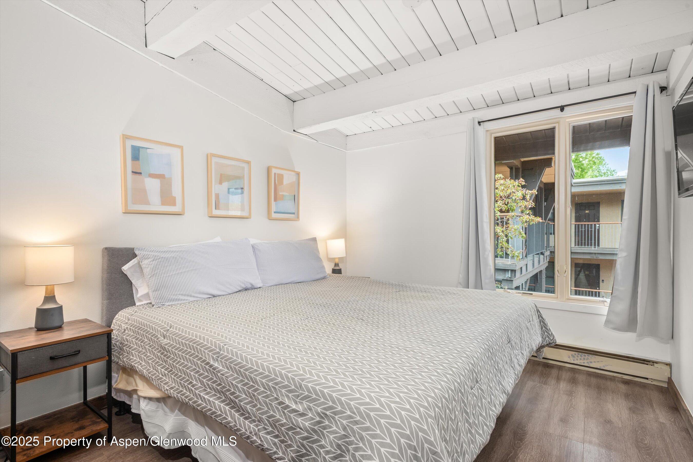 1039 East Cooper Avenue, Unit 36B Aspen, CO 81611 - Photo 12 of 15 a bedroom with a large bed and a window
