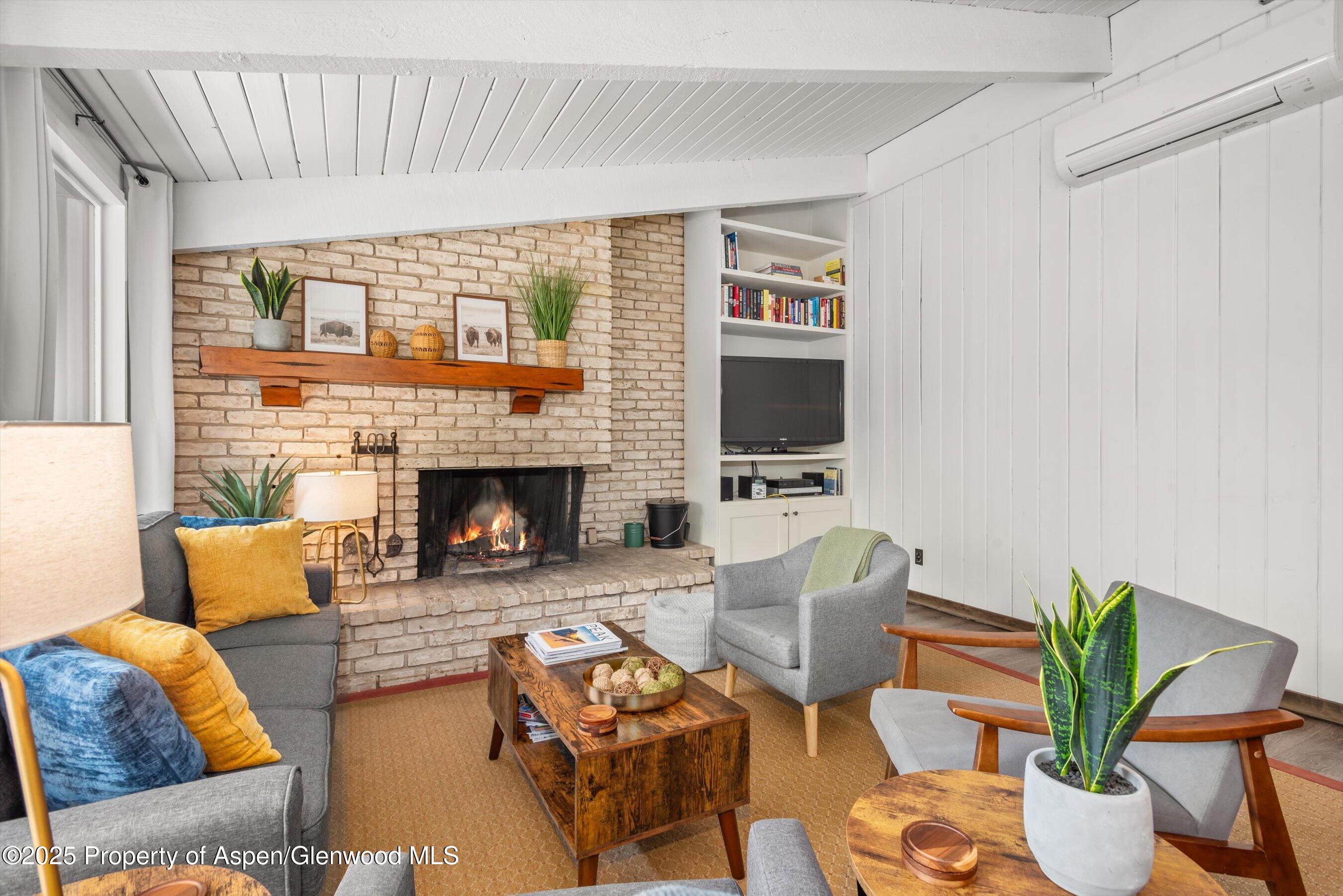 1039 East Cooper Avenue, Unit 36B Aspen, CO 81611 - Photo 3 of 15 a living room with furniture a flat screen tv and a fireplace