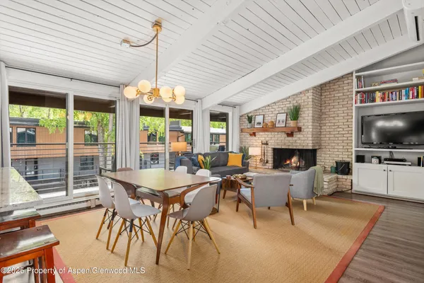 a dining room with furniture a fireplace and wooden floor