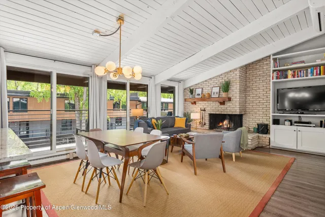 a dining room with furniture a fireplace and wooden floor