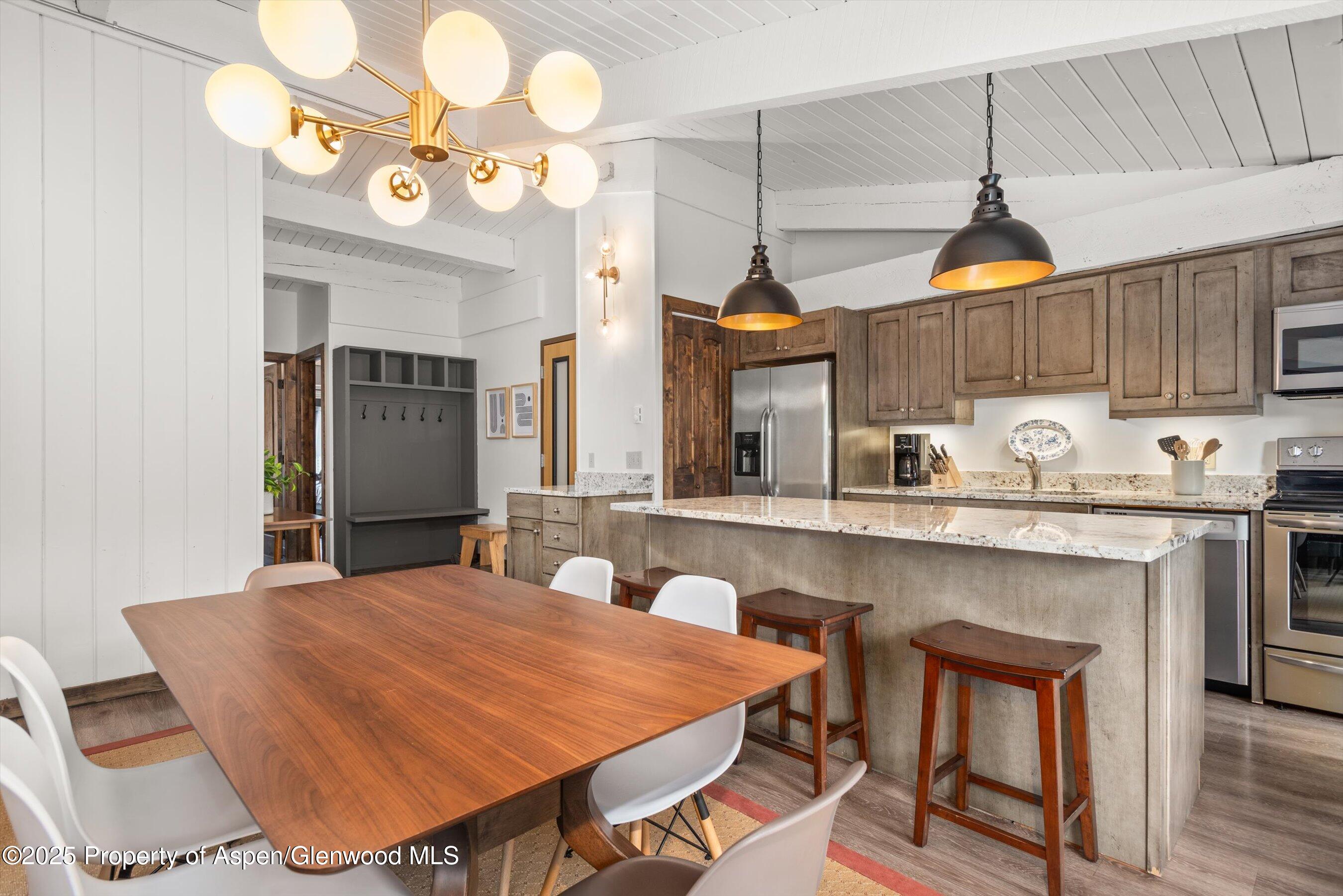 1039 East Cooper Avenue, Unit 36B Aspen, CO 81611 - Photo 6 of 15 a kitchen with a table chairs and a chandelier