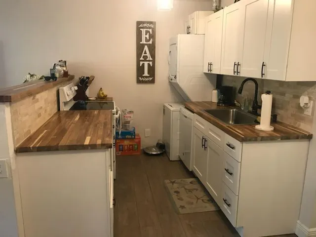 a kitchen with a refrigerator and white cabinets