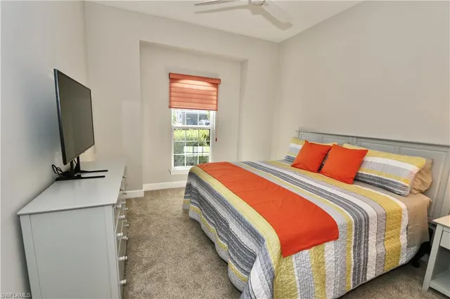 a bedroom with bed and a flat tv screen on dresser