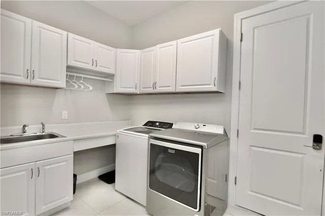 a utility room with sink dryer and washer