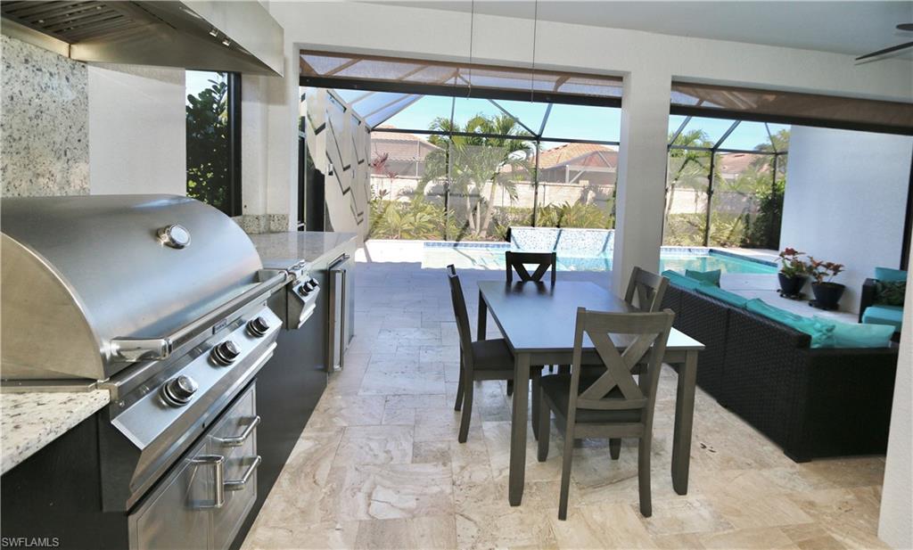 8191 Lucello Terrace North Naples, FL 34114 - Photo 24 of 42 View of patio featuring glass enclosure, outdoor dining space, an outdoor pool, a sunroom, and exterior kitchen