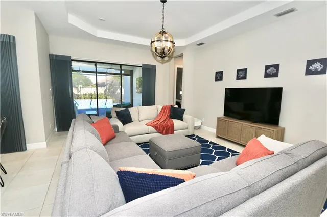 a living room with furniture a flat screen tv and a large window