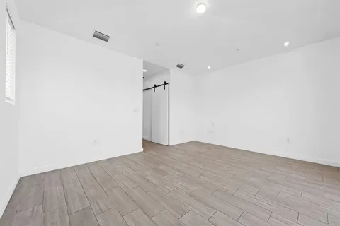 a view of an empty room with wooden floor