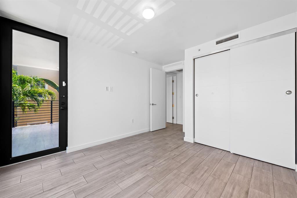 722 Northeast 15th Avenue, Unit 2 Fort Lauderdale, FL 33304 - Photo 14 of 27 a view of hallway with a large window and wooden floor