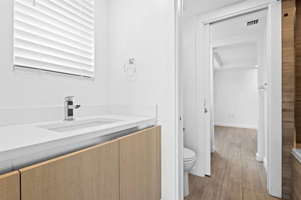722 Northeast 15th Avenue, Unit 2 Fort Lauderdale, FL 33304 - Photo 19 of 27 a bathroom with a granite countertop sink a toilet and a window