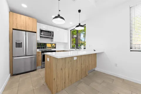 a kitchen with stainless steel appliances granite countertop a sink a refrigerator and a stove