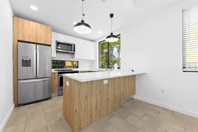 a kitchen with stainless steel appliances granite countertop a sink a refrigerator and a stove