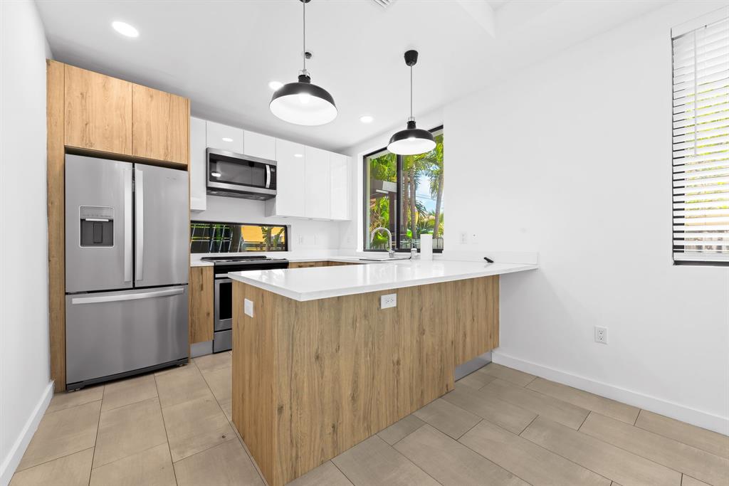 722 Northeast 15th Avenue, Unit 2 Fort Lauderdale, FL 33304 - Photo 5 of 27 a kitchen with stainless steel appliances granite countertop a sink a refrigerator and a stove