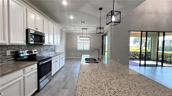 a kitchen with stainless steel appliances granite countertop a sink refrigerator and microwave