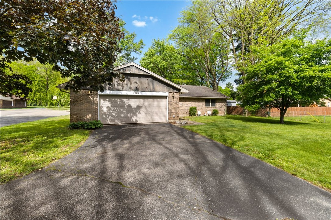 7225 Garber Road Clayton, OH 45415 - Photo 5 of 33 This charming residence features a classic brick exterior and a welcoming driveway, nestled within a lush green yard.