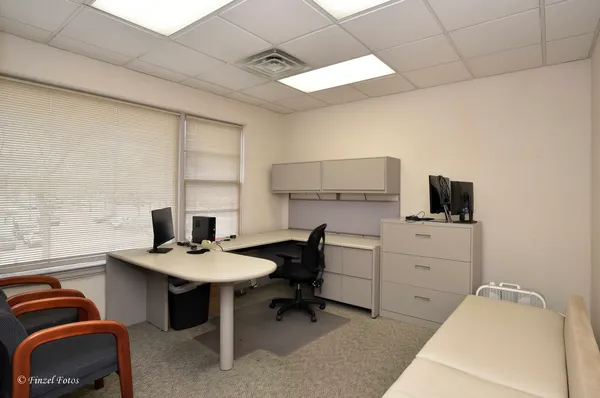 a view of a livingroom with workspace and windows