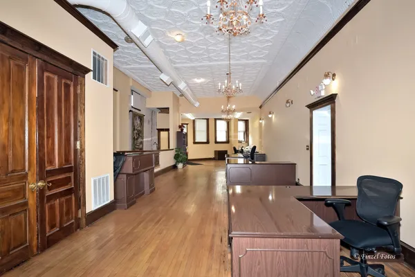 a view of a dining room with furniture a chandelier and wooden floor