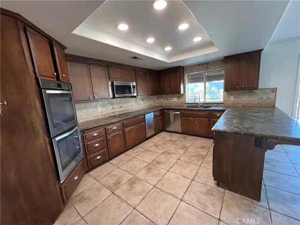 a kitchen with stainless steel appliances granite countertop a sink counter space cabinets and a large window