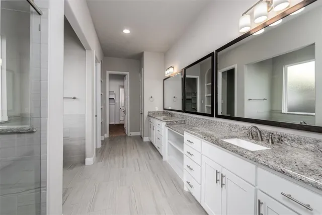 a spacious bathroom with a double vanity sink and a mirror