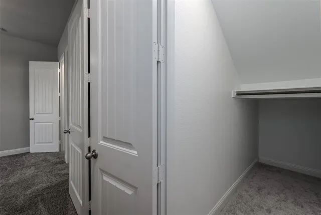 an empty room with fan closet and fan