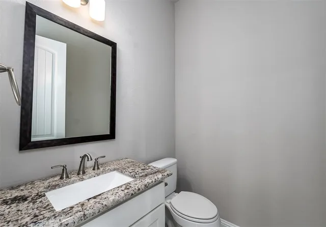 a bathroom with a granite countertop sink a toilet and bathtub