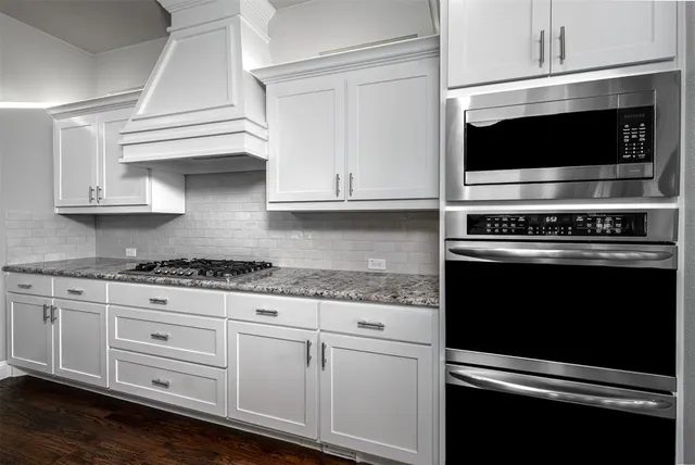 a kitchen with stainless steel appliances granite countertop a stove microwave and cabinets