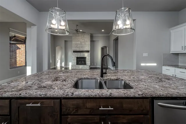 a kitchen with kitchen island granite countertop stainless steel appliances a sink stove and refrigerator