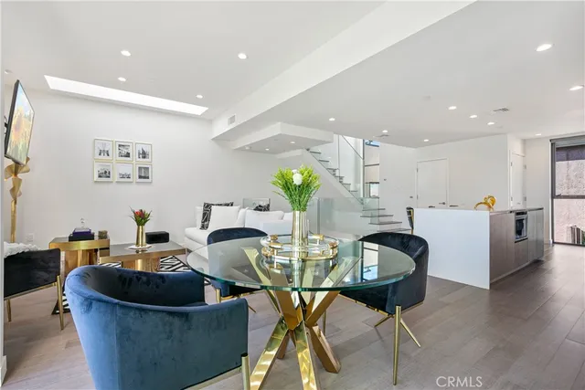 a living room with furniture and a dining table with wooden floor