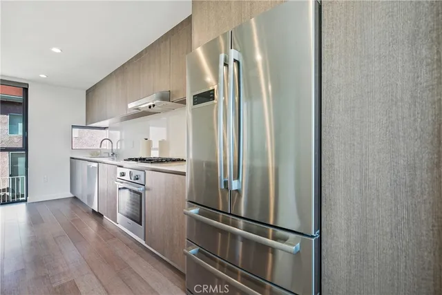 a kitchen with stainless steel appliances granite countertop a refrigerator and a stove top oven