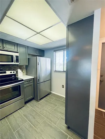 a kitchen with stainless steel appliances granite countertop a refrigerator and a stove top oven