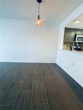 a view of a room with wooden floor and white walls