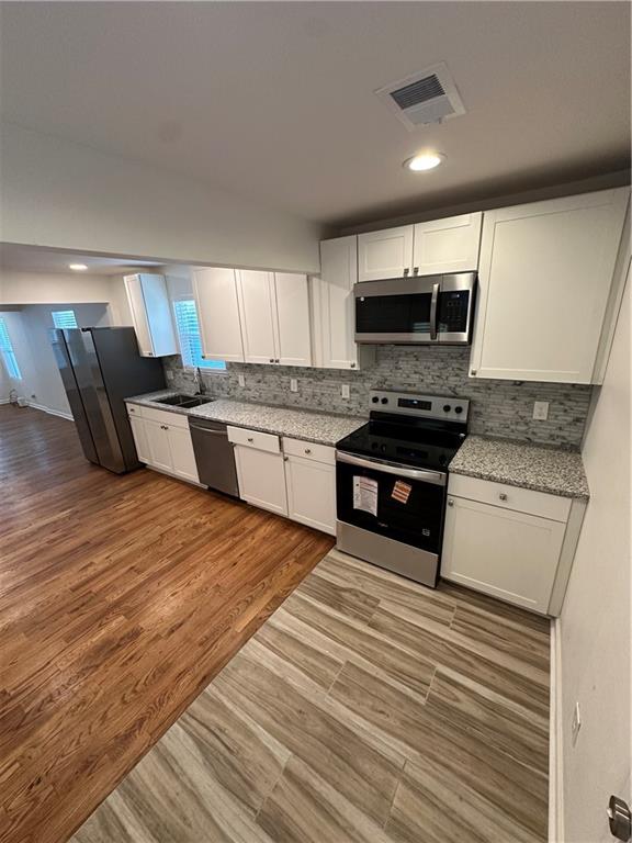 1577 Campbellton Road Southwest Atlanta, GA 30311 - Photo 18 of 23 a kitchen with stainless steel appliances granite countertop a stove a sink and a microwave