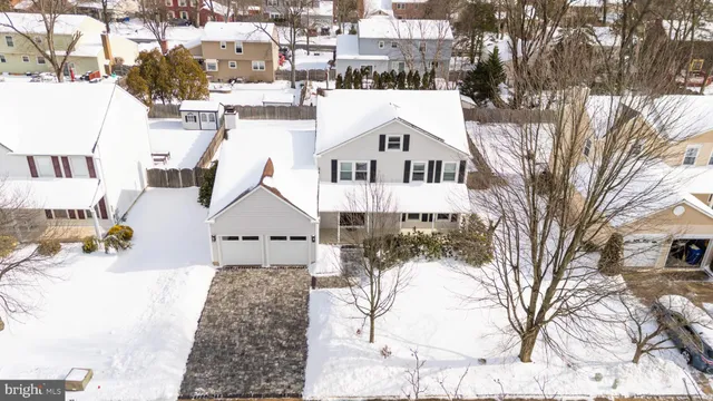 a view of a white house with a yard covered in snow