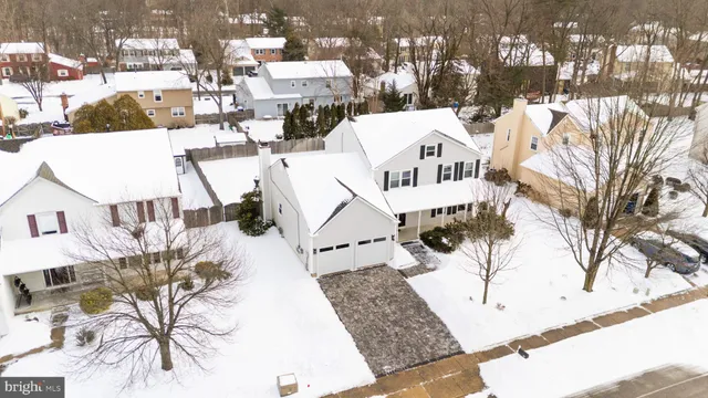 a view of a white house with a yard covered with snow