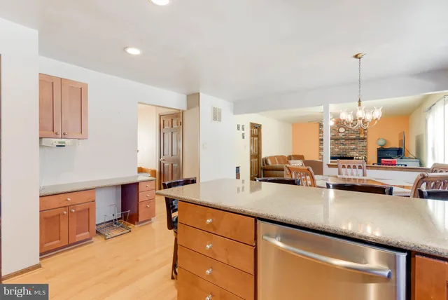 a kitchen with stainless steel appliances granite countertop a sink counter space and living room view