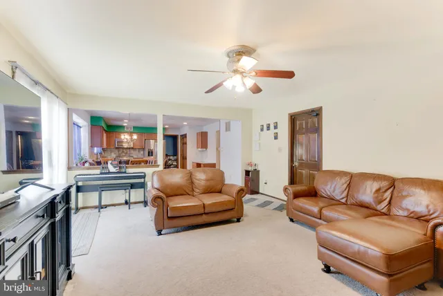 a living room with furniture kitchen view and a chandelier