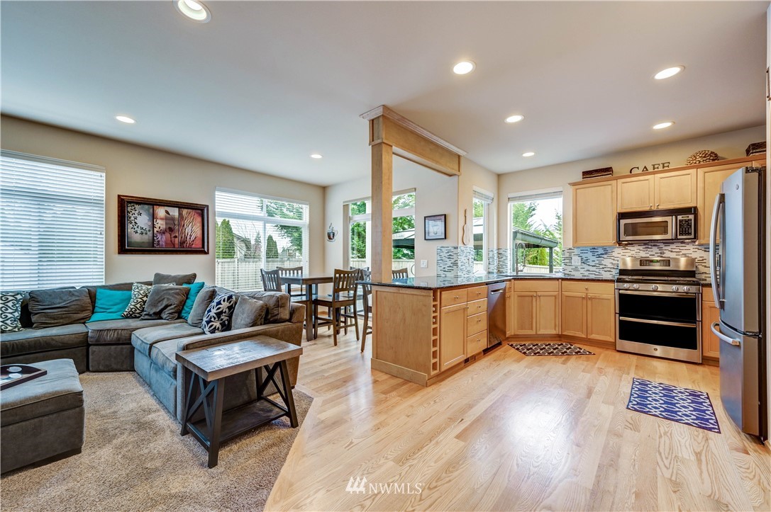 5719 Northeast 3rd Street Renton, WA 98059 - Photo 20 of 40 a large living room with stainless steel appliances granite countertop a couch and a view of kitchen