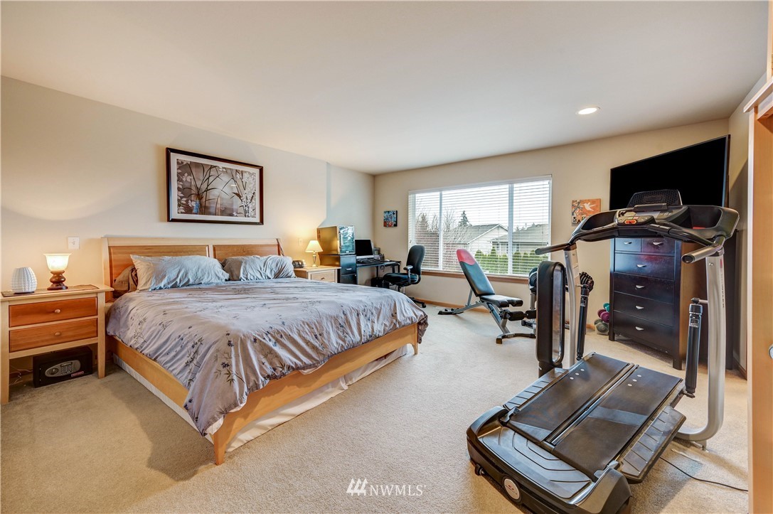 5719 Northeast 3rd Street Renton, WA 98059 - Photo 26 of 40 a spacious bedroom with a bed and a flat screen tv