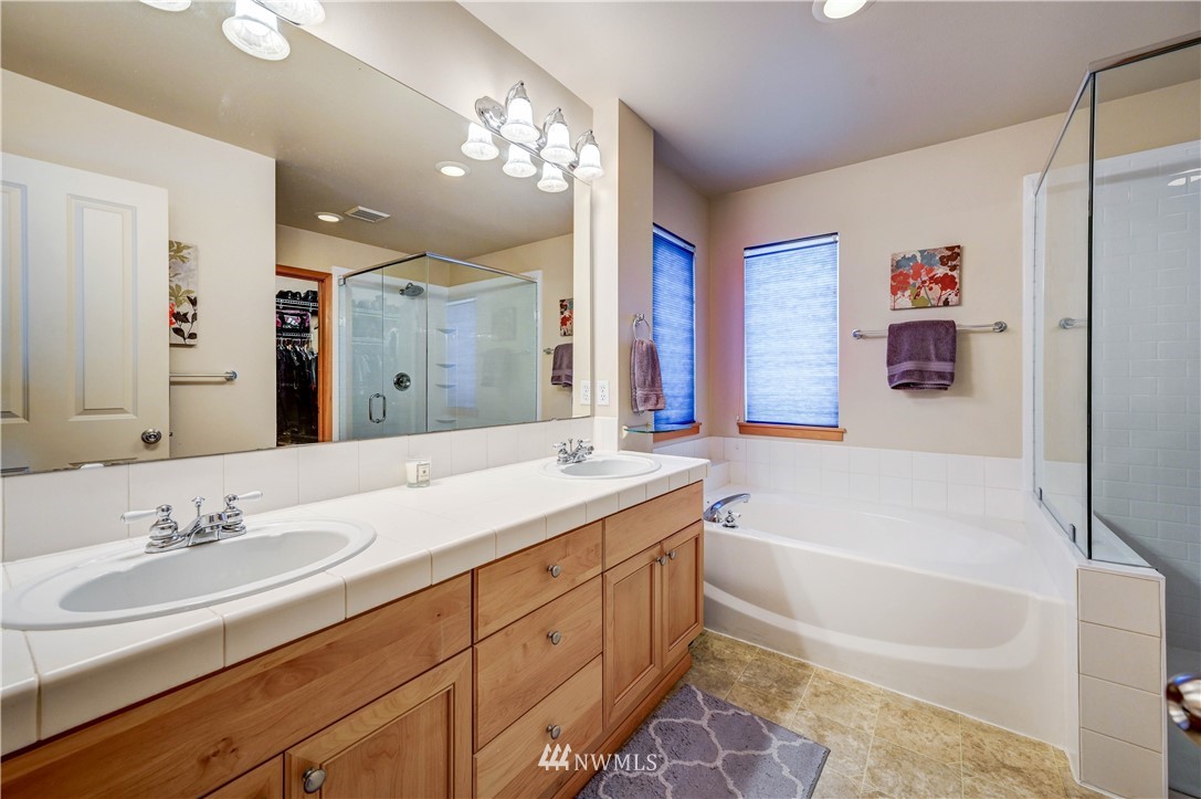 5719 Northeast 3rd Street Renton, WA 98059 - Photo 28 of 40 a bath room with a sink vanity tub and a mirror