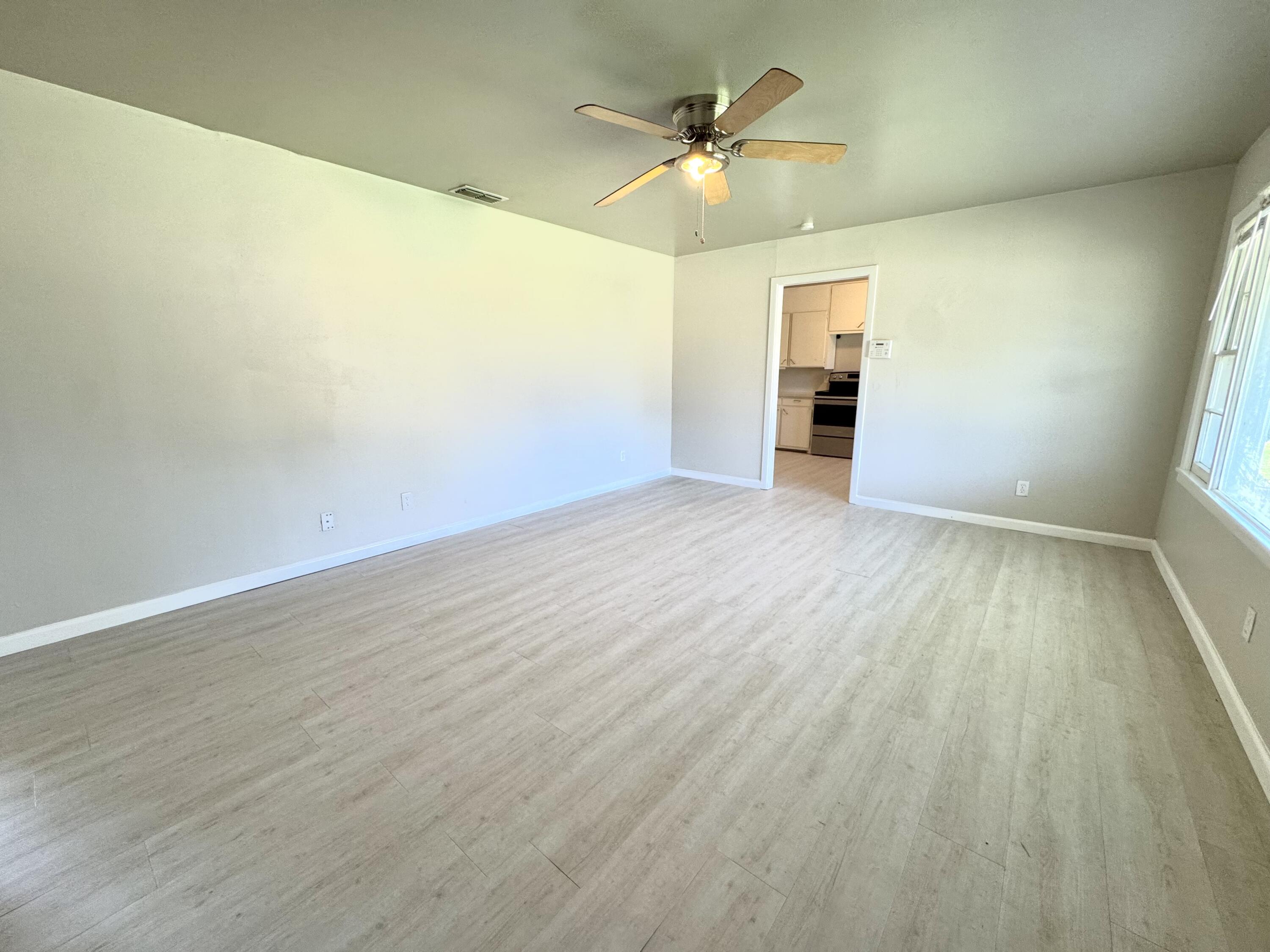 3805 35th Street Lubbock, TX 79413 - Photo 2 of 11 wooden floor in an empty room with a window