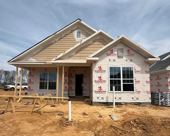a front view of a house with a large window and potted plants