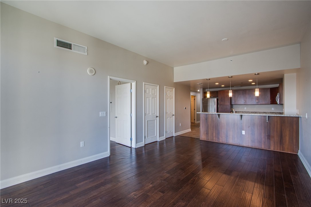 150 South Las Vegas Boulevard, Unit 1212 Las Vegas, NV 89101 - Photo 12 of 45 Unfurnished living room featuring baseboards and dark wood-type flooring