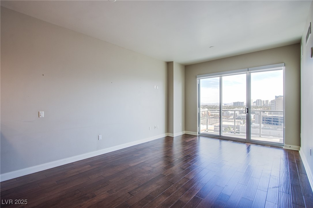 150 South Las Vegas Boulevard, Unit 1212 Las Vegas, NV 89101 - Photo 13 of 45 Empty room featuring dark wood-type flooring, baseboards, and a city view