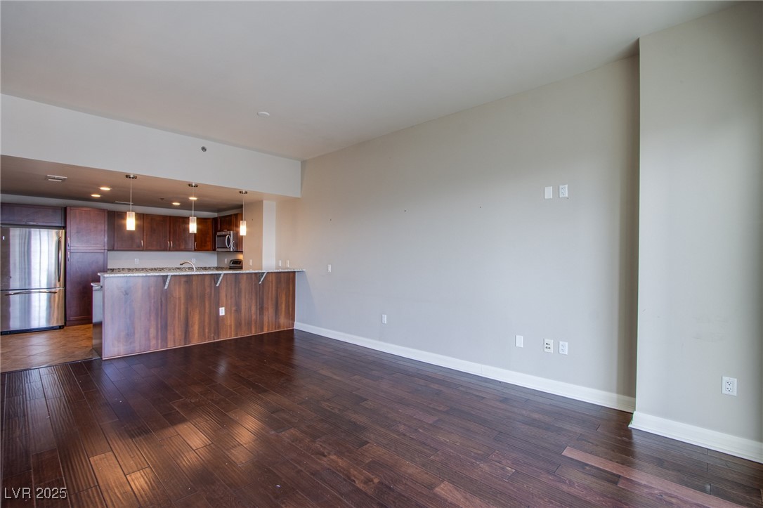 150 South Las Vegas Boulevard, Unit 1212 Las Vegas, NV 89101 - Photo 14 of 45 Kitchen with stainless steel appliances, a peninsula, dark wood finished floors, light countertops, and baseboards