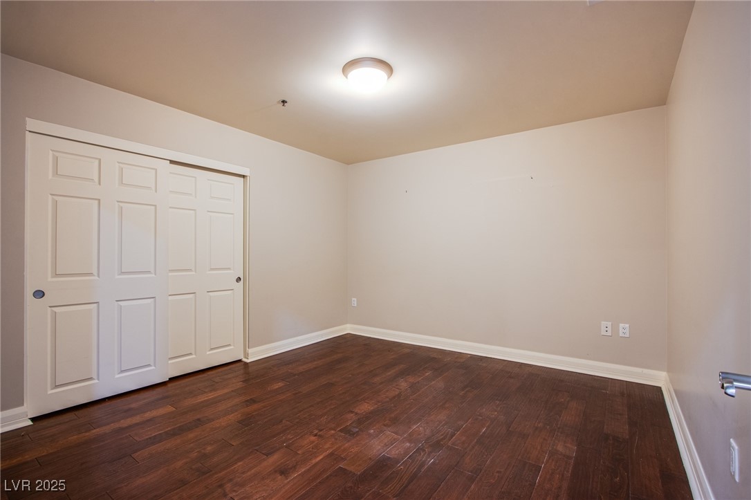 150 South Las Vegas Boulevard, Unit 1212 Las Vegas, NV 89101 - Photo 16 of 45 Unfurnished bedroom featuring dark wood-type flooring and baseboards