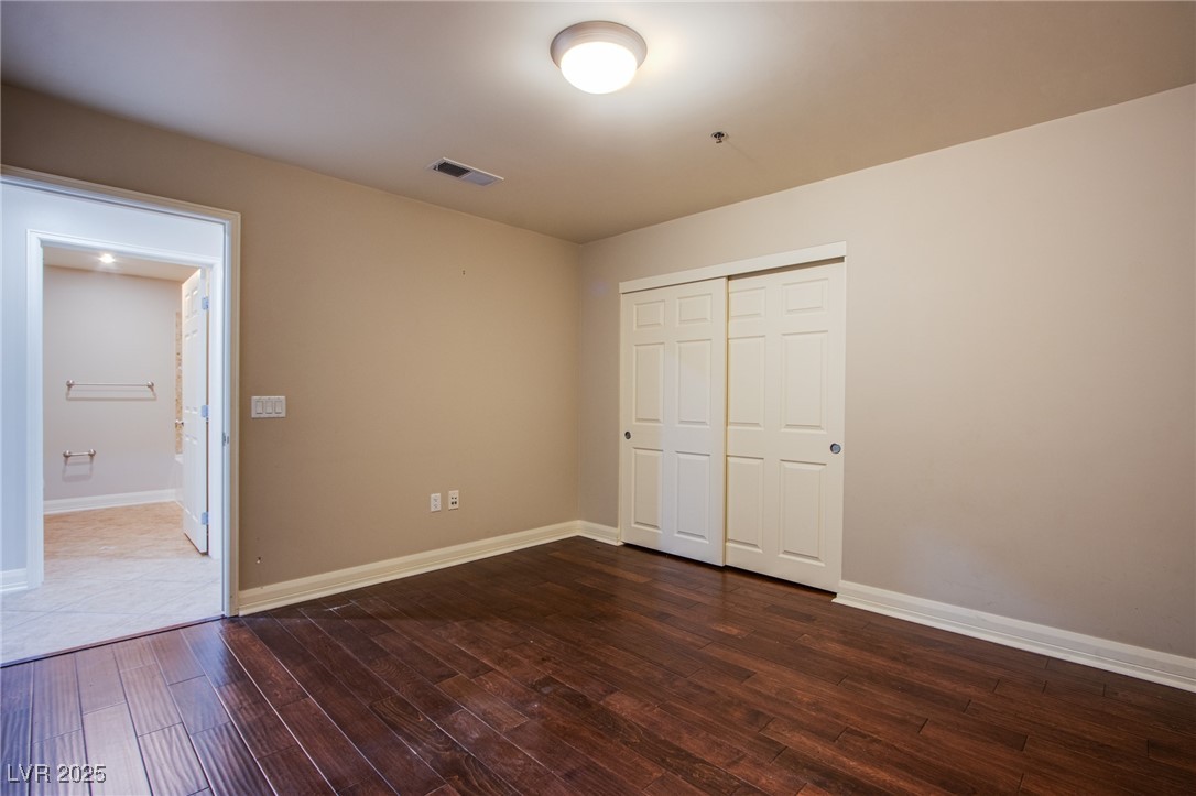 150 South Las Vegas Boulevard, Unit 1212 Las Vegas, NV 89101 - Photo 17 of 45 Unfurnished bedroom featuring dark wood-type flooring, a closet, and baseboards