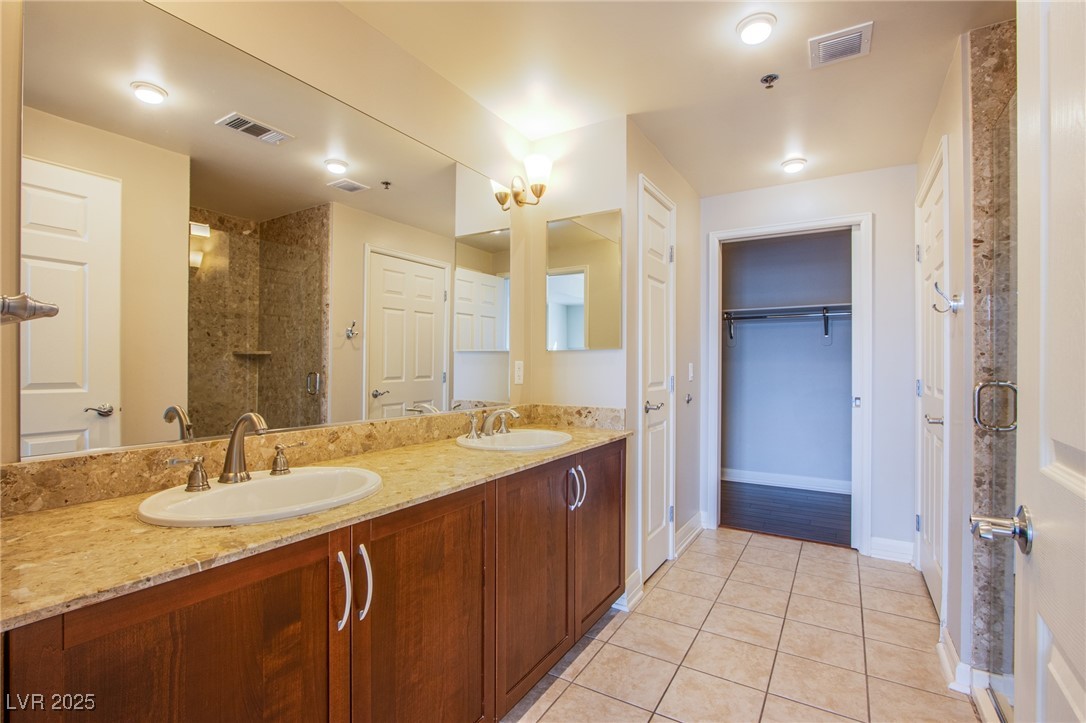 150 South Las Vegas Boulevard, Unit 1212 Las Vegas, NV 89101 - Photo 22 of 45 Full bathroom featuring tile patterned flooring, double vanity, baseboards, and a tile shower